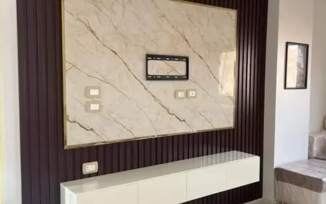 TV-Wand in Beige mit Goldrahmen